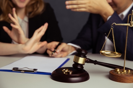 Image of two people arguing and a clipboard and gavel in front of them