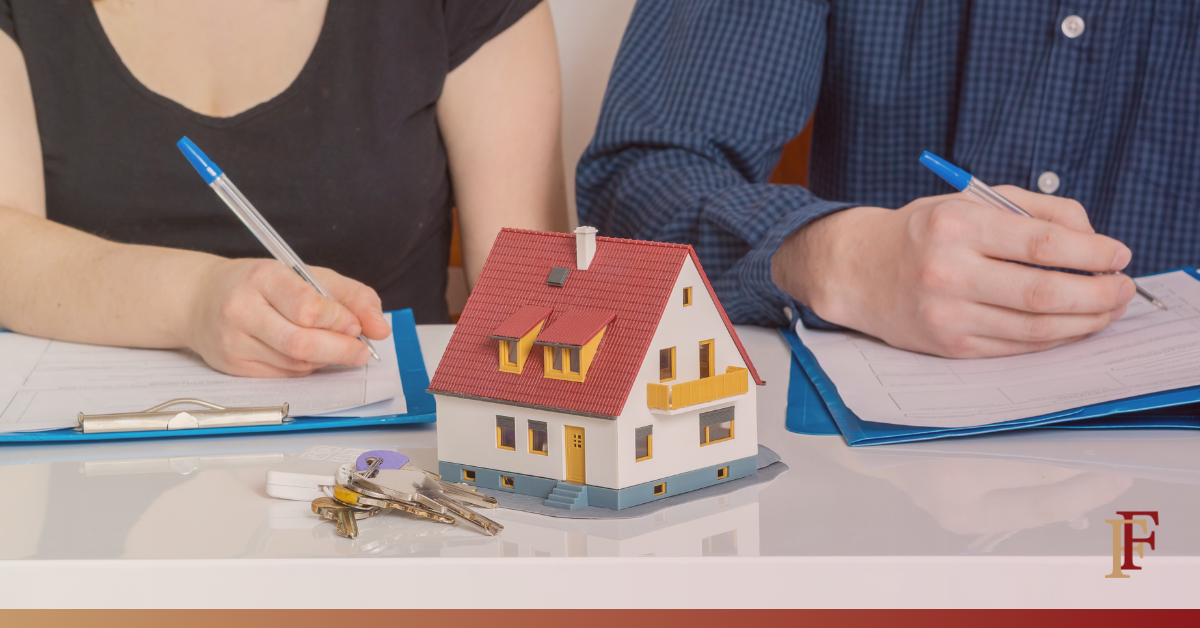 image of two people signing documents with a toy house between them