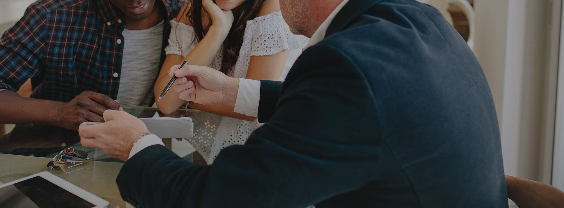 A divorce attorney handing divorce papers and a pen to a couple